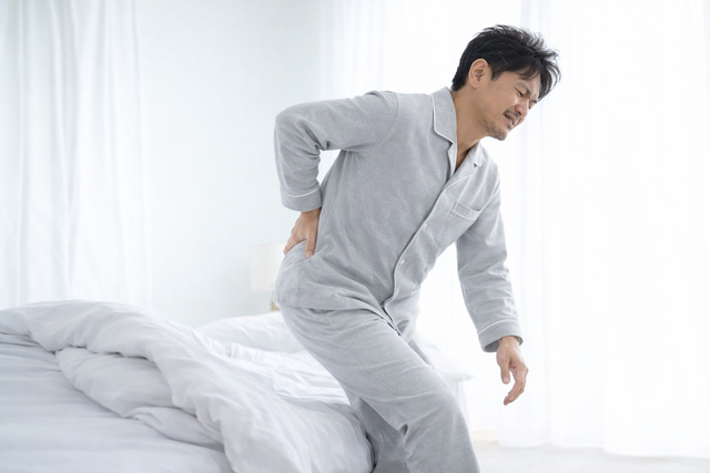 朝の腰痛に悩む男性